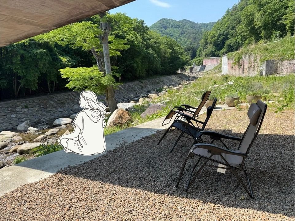 川辺の外気浴チェアでくつろぐ人の後ろ姿