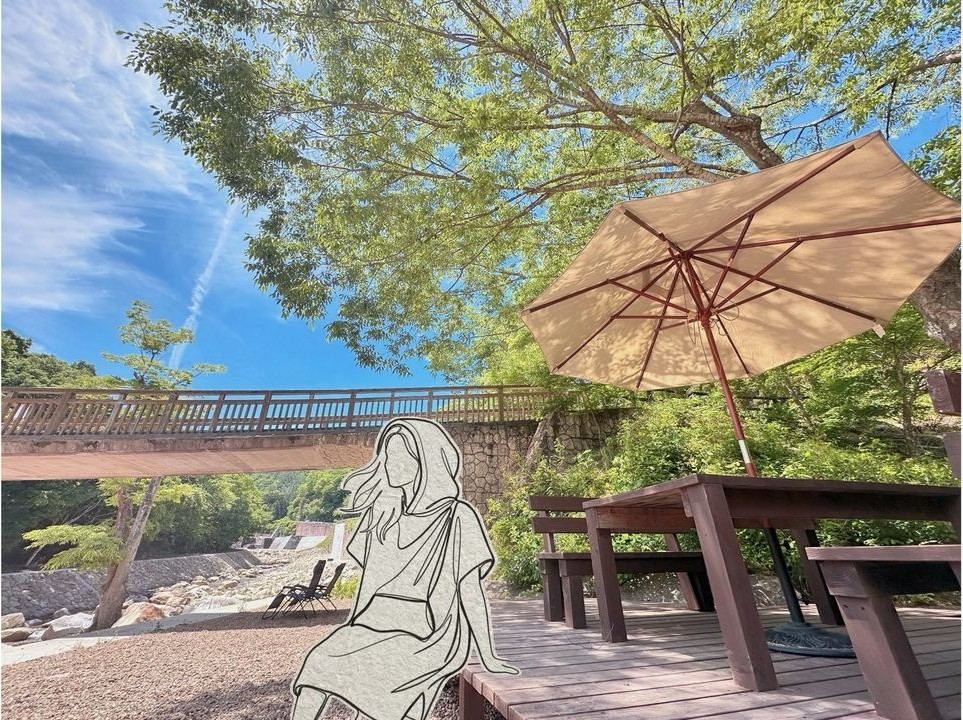 デッキで橋を望みながらくつろぐ人の後ろ姿